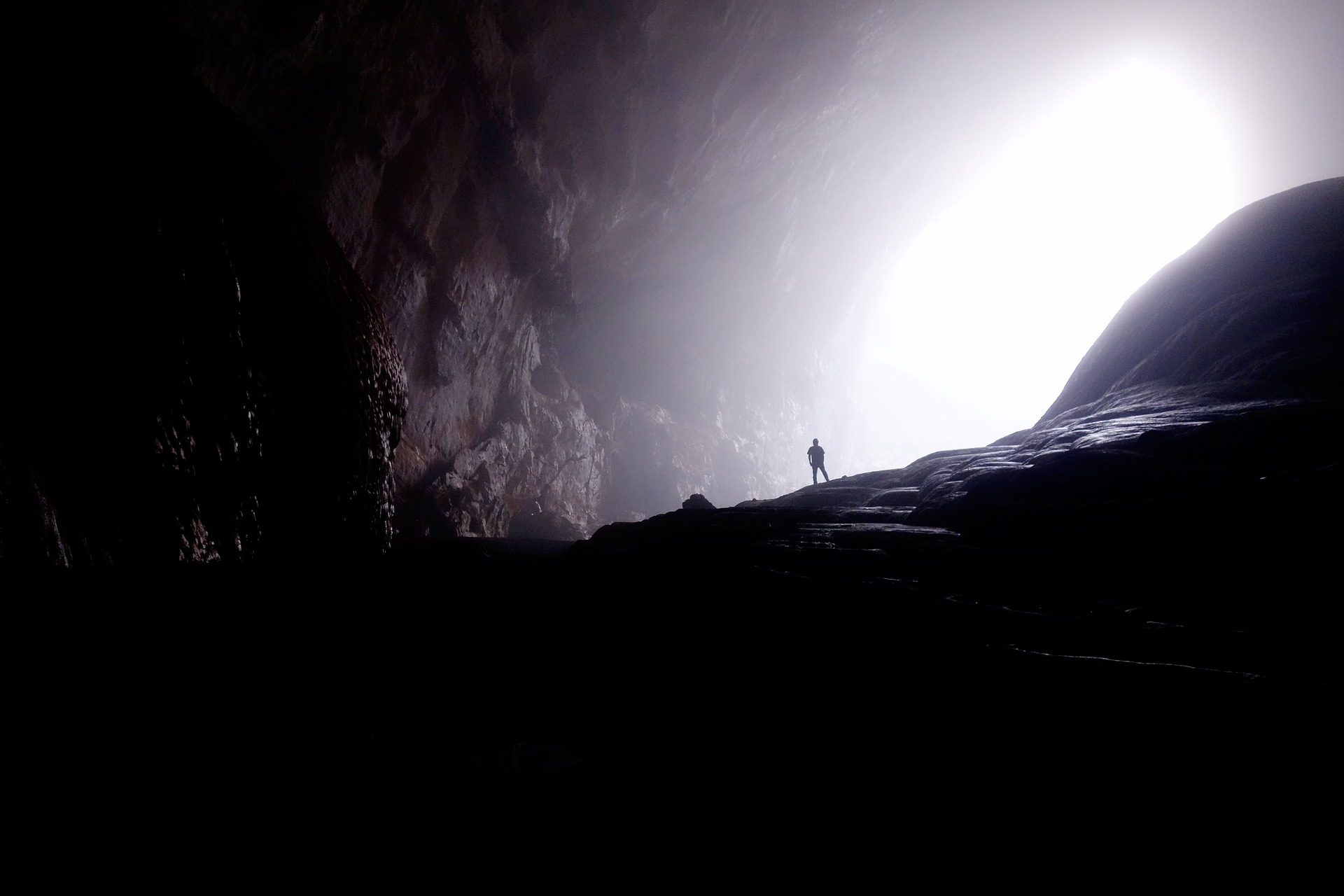 Person in cave Person standing in a cave